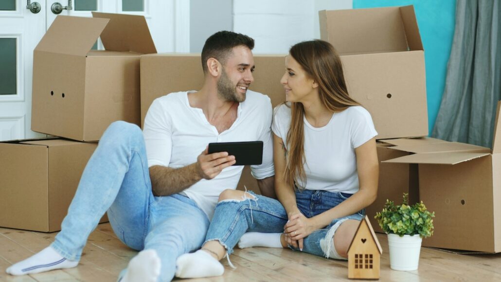 vitaly-gariev-YDyRz7DmirA-unsplash | Home Alarms Canada Young couple celebrating their new home, checking the new homeowner security checklist
